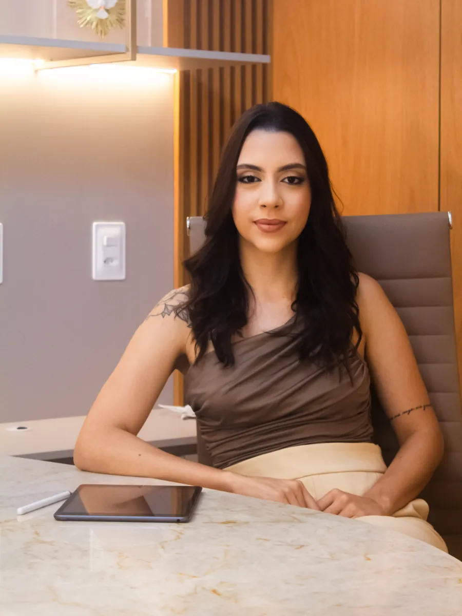 Dra. Ana Beatriz sentada à mesa do consultório